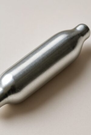 A silver nitrous oxide canister on a neutral background