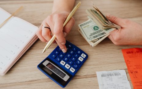 Hands handling cash and calculator for budget planning. Modern financial scene. — Factors That Affect Your Life Insurance Pre